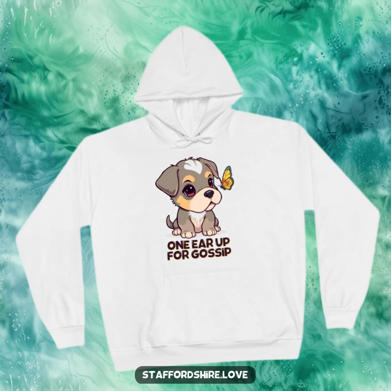 Funny Staffordshire pup with one ear flopped over, looking curiously at a fluttering butterfly on a warm, cozy hoodie.